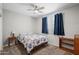 Carpeted bedroom with ceiling fan, bedside table, and window with dark curtains at 2243 E Cortez Dr, Gilbert, AZ 85234