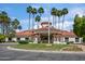 Stunning clubhouse exterior with well-manicured landscaping, towering palm trees, and tile roof at 2243 E Cortez Dr, Gilbert, AZ 85234