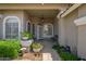 Inviting covered front porch with potted plants, seating, and decorative details around arched windows at 2243 E Cortez Dr, Gilbert, AZ 85234