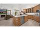 Open kitchen featuring custom cabinets, stainless steel appliances, a center island, and backyard access at 2243 E Cortez Dr, Gilbert, AZ 85234