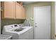 Well-organized laundry room featuring a modern washer and dryer set, built-in cabinets and a convenient ironing board at 2243 E Cortez Dr, Gilbert, AZ 85234