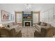 Well-lit living room with large area rug, fireplace, ceiling fan, and comfortable seating at 2243 E Cortez Dr, Gilbert, AZ 85234