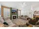 Spacious living room with a cozy fireplace, ceiling fan, and comfortable seating arrangement at 2243 E Cortez Dr, Gilbert, AZ 85234