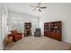 Bright living room features arched windows with shutters, bookshelves, comfortable seating and a ceiling fan at 2243 E Cortez Dr, Gilbert, AZ 85234