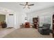 Bright living room features arched windows with shutters, bookshelves, comfortable seating and a ceiling fan at 2243 E Cortez Dr, Gilbert, AZ 85234