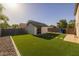A pristine backyard featuring artificial grass, a charming shed, and well-maintained landscaping at 2661 E Los Alamos Ct, Gilbert, AZ 85295