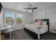 Bedroom featuring a black bed frame, ceiling fan, and a dedicated work space at 2661 E Los Alamos Ct, Gilbert, AZ 85295