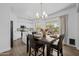Elegant dining area with wood flooring, table setting for four, and open access to the kitchen at 2661 E Los Alamos Ct, Gilbert, AZ 85295