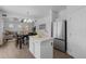 Open kitchen with an island, stainless steel appliances, and wood-look flooring flowing to the dining area at 2661 E Los Alamos Ct, Gilbert, AZ 85295