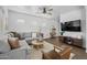 Bright living room with a gray sectional sofa, wooden floors, and a ceiling fan at 2661 E Los Alamos Ct, Gilbert, AZ 85295
