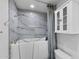 Accessible bathroom features a walk-in tub with marble-look tile surround and white storage cabinet at 2804 N Nebraska St, Chandler, AZ 85225