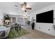 Bright living room with wood floors, ample natural light, ceiling fan, and large TV at 2804 N Nebraska St, Chandler, AZ 85225