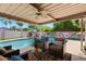 Backyard pool with covered patio, outdoor seating, ceiling fan, and vibrant mural on privacy wall at 2804 N Nebraska St, Chandler, AZ 85225