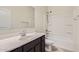 Well-lit bathroom featuring a shower-tub combo, a single-sink vanity, and a large mirror at 30996 W Osborn Rd, Buckeye, AZ 85396