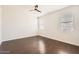 Bright bedroom featuring dark wood flooring, a ceiling fan, and two large windows at 30996 W Osborn Rd, Buckeye, AZ 85396