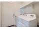 Laundry room featuring a full-size washer and dryer, along with shelving for storage at 30996 W Osborn Rd, Buckeye, AZ 85396
