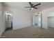 Spacious bedroom features neutral carpet, modern ceiling fan, and ensuite bathroom at 3208 N El Dorado Dr, Chandler, AZ 85224