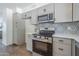 Modern kitchen featuring stainless steel appliances, stylish backsplash, and gray cabinetry at 3208 N El Dorado Dr, Chandler, AZ 85224