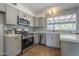 Updated kitchen boasts sleek stainless steel appliances and modern gray cabinets at 3208 N El Dorado Dr, Chandler, AZ 85224