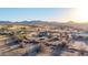 Desert community with sparse foliage and one-story ranch homes; mountainous horizon at 3349 N Ralston Rd, Maricopa, AZ 85139