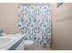 A close-up of a bathtub with shower curtain and tiled walls with neutral colors at 3349 N Ralston Rd, Maricopa, AZ 85139