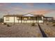 Inviting one-story home featuring a covered front porch, porte-cochere, and a gravel yard for low-maintenance living at 3349 N Ralston Rd, Maricopa, AZ 85139