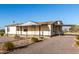 A charming one-story home with a covered front porch and porte-cochere surrounded by desert landscaping at 3349 N Ralston Rd, Maricopa, AZ 85139