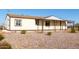A charming, one-story home featuring a covered front porch and attached porte-cochere, surrounded by gravel landscaping at 3349 N Ralston Rd, Maricopa, AZ 85139