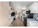 Open kitchen with white cabinets, black appliances, tile backsplash, and wood floors at 3349 N Ralston Rd, Maricopa, AZ 85139