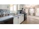 Updated kitchen features white cabinets, wood floors, and black appliances at 3349 N Ralston Rd, Maricopa, AZ 85139