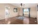 Bright living room featuring hardwood floors, neutral walls, ceiling fan, and blue accent curtains at 3349 N Ralston Rd, Maricopa, AZ 85139