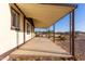 View of a long covered porch featuring a concrete floor and brown support beams, adding a charming outdoor space at 3349 N Ralston Rd, Maricopa, AZ 85139