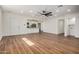 Bright living room featuring new wood floors, fresh white paint, a ceiling fan, and a doorway to the kitchen at 3441 E Taylor St, Phoenix, AZ 85008