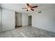 This bedroom features neutral paint, updated tile flooring, and an included ceiling fan at 3810 N Maryvale Pkwy # 1059, Phoenix, AZ 85031
