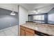 Partial view of a kitchen showcasing wooden cabinetry and an eat-in counter overlooking the living room at 3810 N Maryvale Pkwy # 1059, Phoenix, AZ 85031