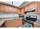 Well-equipped kitchen featuring wood cabinetry, appliances, and good lighting at 3810 N Maryvale Pkwy # 1059, Phoenix, AZ 85031