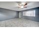 Spacious living room featuring neutral tile flooring, a ceiling fan, and a large window at 3810 N Maryvale Pkwy # 1059, Phoenix, AZ 85031