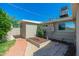 Exterior view of the home's backyard with a small tree garden, brick pathway, and clean landscaping at 3822 W Flower St, Phoenix, AZ 85019