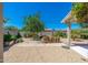 Spacious backyard featuring a lush tree, gravel, and stone pavers creating a serene outdoor oasis at 3822 W Flower St, Phoenix, AZ 85019