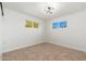 Bedroom with dual windows providing natural light and plush carpet flooring at 3822 W Flower St, Phoenix, AZ 85019