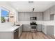Bright modern kitchen with gray cabinets, quartz countertops and stainless steel appliances at 3822 W Flower St, Phoenix, AZ 85019
