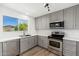 Bright modern kitchen with gray cabinets, quartz countertops and stainless steel appliances at 3822 W Flower St, Phoenix, AZ 85019