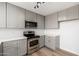 Bright modern kitchen features gray cabinets, stainless steel appliances and contemporary lighting at 3822 W Flower St, Phoenix, AZ 85019