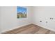 Bright laundry room with light wood-look flooring and a window offering ample natural light at 3822 W Flower St, Phoenix, AZ 85019