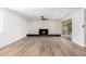 Bright living room with fireplace, modern ceiling fan and sliding glass doors leading to patio at 3822 W Flower St, Phoenix, AZ 85019