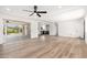 Bright open-concept living room features wood-look flooring, sliding glass doors, and neutral palette at 3822 W Flower St, Phoenix, AZ 85019