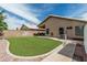 Well maintained backyard features an easily maintained lawn, rock accents, and concrete walkway at 3856 E Encinas Ave, Gilbert, AZ 85234