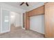 Comfortable bedroom with carpet flooring, a ceiling fan, built-in cabinet, and a doorway to another room at 3886 E Ficus Way, Gilbert, AZ 85298