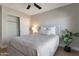 Bright bedroom features a ceiling fan, closet, and a comfortable bed with a decorative headboard at 3925 N 160Th Ave, Goodyear, AZ 85395