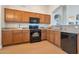Bright kitchen showcases wooden cabinetry, granite countertops, and updated black appliances for a modern, functional cooking space at 3925 N 160Th Ave, Goodyear, AZ 85395